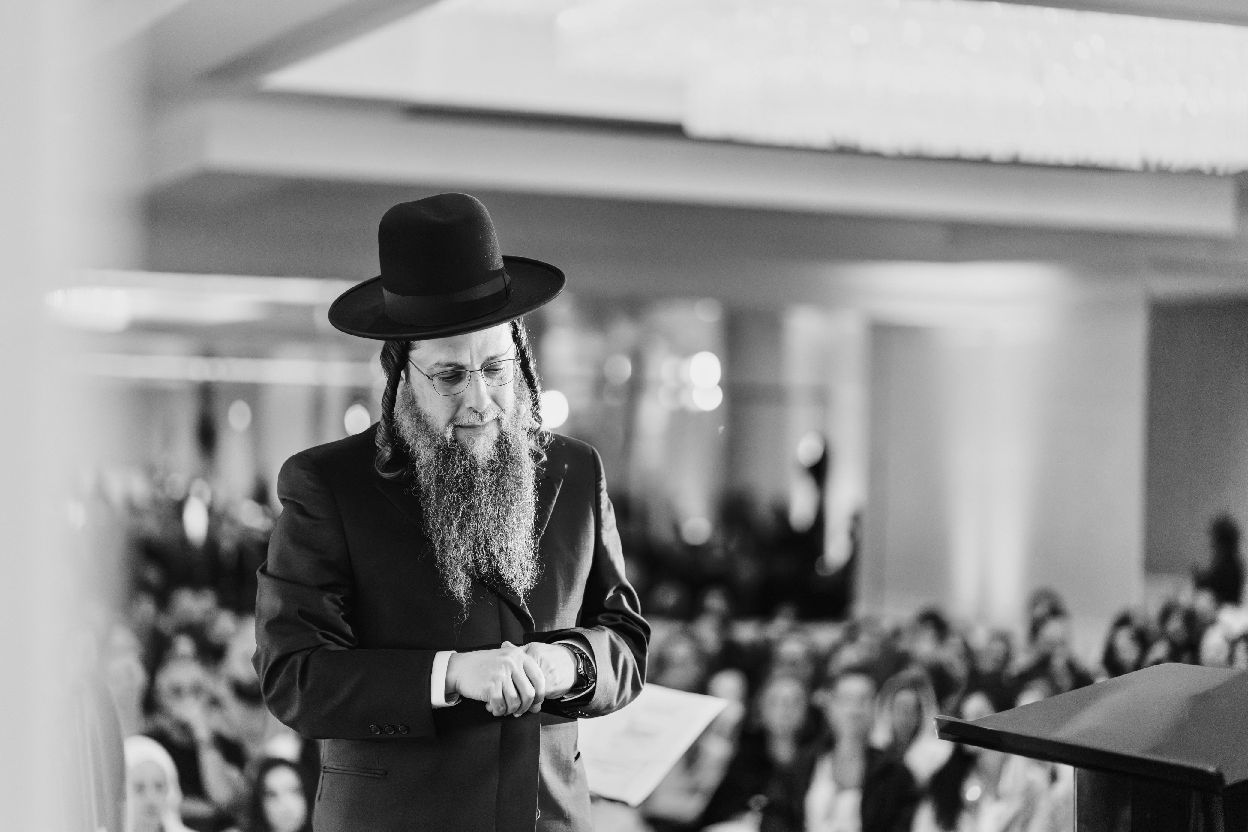 Rav Doniel at the podium, head bowed